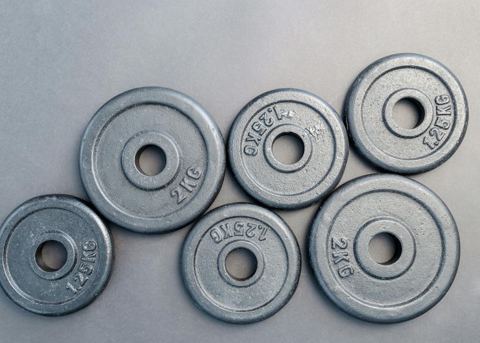 Close up of steel workout plates in dark gym